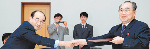 남북 적십자회담 남측 수석대표인 김영철 대한적십자사 사무총장(왼쪽)과 북측 단장인 최성익 조선적십자회 중앙위원회 부위원장이 28일 금강산호텔에서 합의문을 교환한 뒤 악수하고 있다. 금강산=사진공동취재단