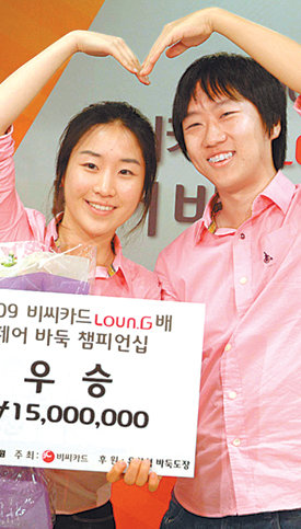 최철한 9단(오른쪽)과 윤지희 2단이 지난달 26일 비씨카드 라운지배 페어바둑 우승 상금으로 1500만 원을 받은 뒤 손으로 하트 모양을 그리고 있다. 사진 제공 사이버오로