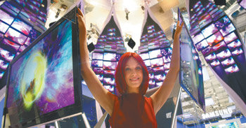 삼성, 132개 LED TV로 ‘디지털 꽃잎’ 설치‘IFA 2009’를 대표하는 ‘미스 IFA’가 2일 삼성전자 부스에서 평면 스크린을 소개하고 있다. ‘4년 연속 세계 TV 시장 1위’ 달성 목표를 세운 삼성전자는 신규 시장 창출에 성공한 발광다이오드(LED) TV를 중심으로 대거 신제품을 선보인다. 베를린=EPA 연합뉴스