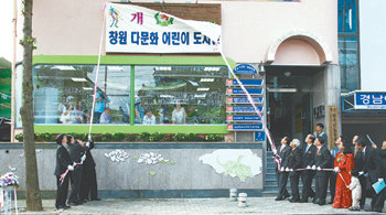 8일 오후 경남 창원시 팔용동 경남이주민사회센터에서 열린 창원다문화어린이도서관 개관식에서 강덕수 STX그룹 회장과 윤병철 사회복지공동모금회장, 김학준 동아일보 회장 등 참석자들이 현판 제막식을 하고 있다. 창원=강정훈 기자