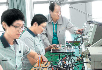 서울북공고 고동석 교사(오른쪽)와 기술사관학교 학생들이 데이터를 전송하는 기계가 정상적으로 작동되는지 시험하고 있다. 사진 제공 서울북공고