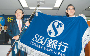 신한은행이 100% 단독 출자해 설립한 일본 현지법인 SBJ은행이 14일 영업을 시작했다. 이백순 신한은행장(왼쪽)과 미야무라 사토루 SBJ은행장이 개업식에서 함께 행기를 들고 있다. 사진 제공 신한은행