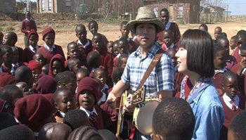 아프리카 남쪽 지역 국가인 레소토를 돕기 위해 나선 아마추어 음악가 이재훈 씨(챙 달린 모자를 쓴 이)와 박연 씨가 레소토 어린이들에게 둘러싸여 노래를 하고 있다. 사진 제공 EBS