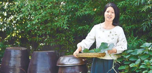 한복연구가 이효재 씨가 24일 서울 성북구 성북동 자택 마당에서 직접 기른 호박잎을 소쿠리에 담은 채 포즈를 취했다. 이 씨는 이 마당에서 10여 가지 채소 등 친환경 먹을거리를 직접 키운다. 아래 작은 사진들은 이 씨가 이날 기자에게 직접 대접한 밥상. 생선구이, 김치, 오이소박이 등 친환경 재료로 차려낸 정갈한 식사였다. 홍진환  기자