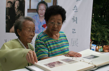 26일 경기 고양시 일산동구 흰돌마을에서는 평범한 할머니들의 특별한 ‘팔순 회고전’이 열렸다. 김수영 할머니(왼쪽)가 마을 주민에게 오래된 사진을 보여주고 있다. 고양=신민기 기자