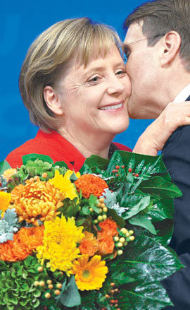 27일 독일 총선에서 기민당(CDU)-기사당(CSU) 연합의 승리를 이끈 앙겔라 메르켈 독일 총리가 로날트 포팔라 기민당 사무총장으로부터 꽃다발과 함께 축하 인사를 받고 있다. 베를린=신화 연합뉴스