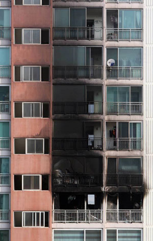 14일 오전 2시께 발생한 화재로 경기도 시흥시 장곡동 S 아파트 12층 류모(44) 씨 집과 위층 바깥쪽이 검게 그을러 있다. 이 불로 류씨와 류씨의 아내(36), 딸(14), 아들(11)이 현장에서 숨지고 류 씨의 아버지(76)는 전신 2도 화상을 입어 인근 신천연합병원으로 옮겨졌으나 의식이 없어 중태다. 연합뉴스