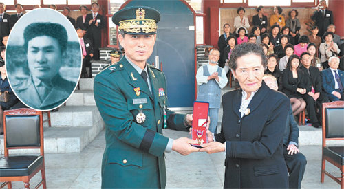 김채운 씨(오른쪽)가 16일 육군사관학교에서 1950년 경기 금곡지구 전투에서 전사한 오빠 김윤택 중령(원 안)의 화랑무공훈장을 받고 있다. 미국에 살고 있는 김 씨는 이날 59년 만에 오빠의 무공훈장을 받기 위해 귀국했다. 사진 제공 육군사관학교