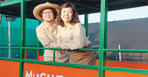 김영표(왼쪽), 남경화 씨 부부가 헌 트랙터를 개조해 만든 ‘버섯마차’에서 포즈를 취하고 있다. 이권효 기자