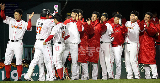 2009 프로야구 한국시리즈 6차전 SK와이번스 대 기아타이거즈 경기가 23일 잠실야구장에 열렸다. 2회말 1사 SK 이호준이 좌월 솔로 홈런을 날리고 홈인해 덕아웃에서 하이파이브 하고 있다. 잠실 | 김종원기자 won@donga.com