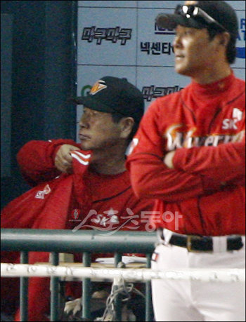 2009프로야구 한국시리즈 7차전 KIA타이거즈 대 SK와이번스의 경기가 24일 서울 잠실야구장에서 열렸다. 5:5 동점 상황 9회말 1사, KIA 나지완이 SK 마무리 투수 채병용을 상대로 결승 솔로 홈런을 날리며 경기를 끝내자 SK벤치의 김성근 감독이 옷을 챙겨 입고 있다. 잠실 | 양회성 기자 yohan@donga.com