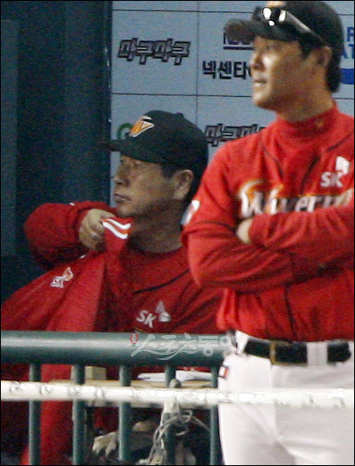 2009프로야구 한국시리즈 7차전 KIA타이거즈 대 SK와이번스의 경기가 24일 서울 잠실야구장에서 열렸다. 5:5 동점 상황 9회말 1사, KIA 나지완이 SK 마무리 투수 채병용을 상대로 결승 솔로 홈런을 날리며 경기를 끝내자 SK벤치의 김성근 감독이 옷을 챙겨 입고 있다. 잠실 | 양회성 기자 yohan@donga.com