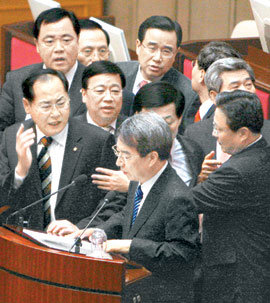 “의사진행 발언 먼저”… 鄭총리 ‘시정연설 대독’ 막는 野의원들 정운찬 국무총리가 2일 국회 본회의에서 이명박 대통령의 시정연설을 대독하려는 순간 김창수 의원(왼쪽) 등 자유선진당 의원들이
단상에 올라 “의사진행 발언을 먼저 해야 한다”며 거세게 항의하고 있다. 민주당과 민주노동당 일부 의원들도 의석에서 정 총리에게
고함을 질렀다. 이종승 기자