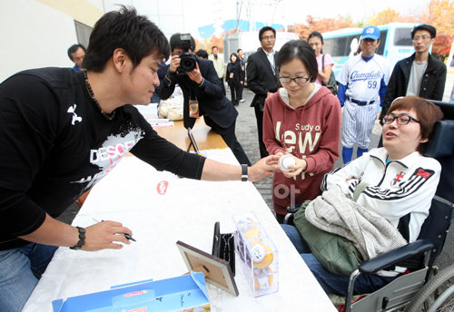 9일 오후 청주야구장에서 진행된 천하무적 야구단과 충주 성심야구부와의 경기에 참가한 메이저리그 추신수가 참가했다. 추신수가 사인회에서 장애우에게 사인을 선물하고 있다.  청주ㅣ 박화용 기자 inphoto@donga.com