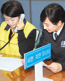 서울 강남구 청담동에 사는 자원봉사자 조연주 씨(왼쪽)가 9일 강남경찰서 사무실에서 일선 경찰과 함께 112 신고자에게 일일이 전화해 사건 처리의 만족도를 조사하고 있다. 사진 제공 강남경찰서