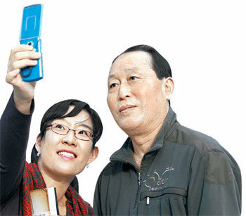 김인식 고문(오른쪽)이 여성 팬의 기념사진 촬영 요청에 응하고 있다. 그는 팬이 내민 노트에 정성껏 사인도 해줬다. 변영욱 기자