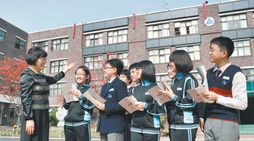 대왕중학교 학생들이 태양광 집열판이 설치된 학교 건물 앞에서 이옥란 교장(왼쪽)으로부터 온실가스 배출을 줄이는 방법에 대한 설명을 듣고 있다. 홍진환 기자