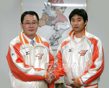 강동우(오른쪽)가 12일 한화와 FA 계약에 합의한 뒤 윤종화 단장과 악수를 나누고 있다. 사진 제공 ｜ 한화 이글스