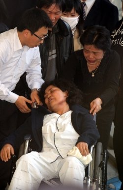 부산 실탄사격장 화재 참사 사망자의 유가족 가운데 한 명이 15일 시신이 안치된 양산부산대병원에서 가족의 시신을 확인한 뒤 실신한 채 휠체어에 실려 나오고 있다. 양산=이훈구 기자ufo@donga.com