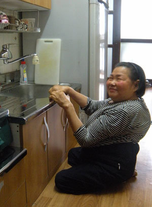 서울 마포구 성산동 시영아파트에 사는 김순녀 할머니가 13일 오후 서울시와 한국장애인개발원이 새로 설치해 준 싱크대 앞에서 환하게 웃고 있다. 두 발을 쓰지 못하는 김 할머니는 18년 동안 이 아파트에서 살았지만 부엌과 화장실을 제대로 이용하지 못했다. 유성열 기자