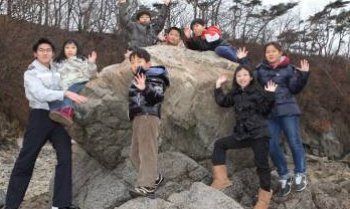 이작분교 학생들과 김봉천 이경(왼쪽)이 수업을 끝내고 대이작도 나루터 옆 바위에 모였다. 전교생이 모두 9명이지만 이날 2명이 뭍에 나가 7명만 학교에 나왔다. 학생들 뒤로 영화 ‘섬마을 선생’에 등장한 ‘문희 소나무’가 보인다. 대이작도=황금천 기자