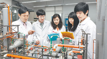 울산대 생명화학공학부 이학성 교수(왼쪽)가 화학공학실험실에서 화학공장의 축소 모형을 통해 복잡한 화학 공정을 설명하고 있다. 사진 제공 울산대