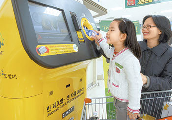 마시고 난 빈 음료 캔과 페트병을 자동으로 분리수거하는 ‘에코로봇’이 할인점에 도입됐다. 신세계 이마트는 17일부터 수도권 이마트 7개 매장과 에브리데이 3개 매장에 에코로봇 1대씩을 설치하고 시범 운영을 시작했다. 서울 성동구 이마트 성수점에서 남선유 양(왼쪽)이 에코로봇에 빈 생수통을 넣고 있다. 박영대 기자