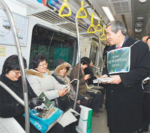 박맹언 부경대 총장(오른쪽)과 교직원들이 18일 달리는 지하철 9호선 열차 안에서 시민들에게 대학 홍보물을 나눠주고 있다. 사진 제공 부경대