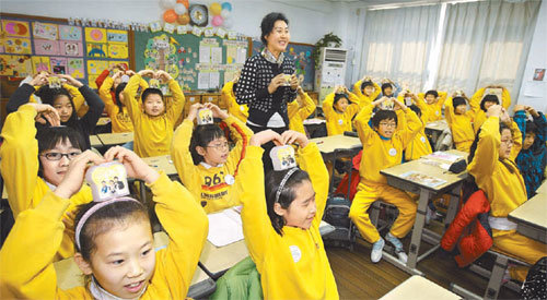 비정부기구인 굿네이버스가 7일 서울 은평구 녹번초등학교 4학년 학생을 대상으로 실시한 세계시민교육 현장. 학생들이 저금통을 들고 손으로 하트 모양을 만들고 있다. 박영대 기자