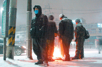 4일 오전 6시경 서울 구로구 가리봉동 지하철 남구로역 5번 출구 앞에서 일자리를 구하지 못한 건설 일용직 노동자들이 버려진 종이박스로 불을 피워 언 손을 녹이고 있다. 노동자 조종수 씨는 휴대전화에 저장한 딸의 사진을 보여주며 “새해 소망은 일거리가 늘어 1000만 원 이상 저금하는 것”이라고 말했다. 조종엽 기자