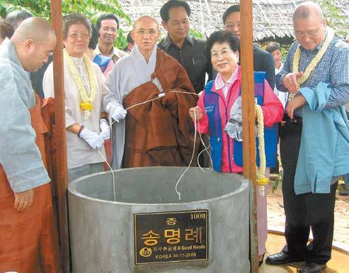 캄보디아 캄폿 주 지아심 고교에서 열린 ‘생명의 우물 1000’ 완공식에서 기증자 송명례 할머니(줄 잡은 이들 중 왼쪽), 지구촌공생회 송월주 이사장(가운데), 전원주 홍보대사 등이 두레박으로 물을 퍼올리고 있다. 사진 제공 지구촌공생회