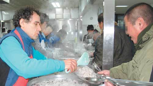 노숙인에게 밥을 퍼주는 김하종 신부(왼쪽). 13년 경력의 ‘밥퍼’ 솜씨가 능숙했다. 그는 “하느님이 주신 앞치마가 내게 가장 잘 어울리는 옷”이라고 말했다. 성남=민병선 기자