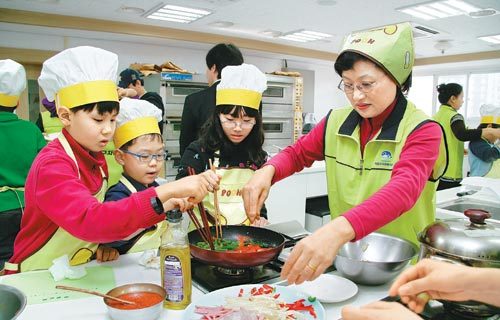 19일 서울 마포구 용강동 중부여성발전센터에서 열린 ‘해피쿠킹스쿨’에 참여한 지역아동센터 어린이들이 자원봉사자와 함께 요리를 하고 있다. 사진 제공 마포구