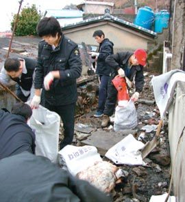 20일 전남 여수시민자활센터 직원 등 자원봉사자 40명이 네 남매에게 새 보금자리를 지어주기 위해 화재 쓰레기 청소를 하고 있다. 사진 제공 여수시