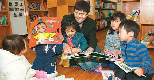 지난달 28일 경남 창원시 팔룡동 경남이주민사회센터의 다문화어린이도서관 ‘모두’에서 이철승 목사(가운데)가 아이들과 함께 책을 읽고 있다. 창원=강정훈 기자