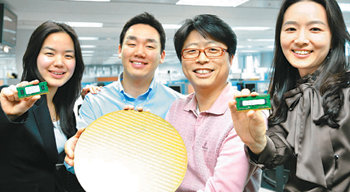 삼성전자 직원들이 이 회사가 세계 최초로 개발한 30nm급 D램 웨이퍼(가운데)와 완성품 D램을 들고 있다. 사진 제공 삼성전자