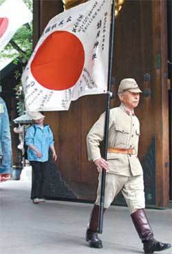 일본의 한 퇴역군인이 야스쿠니 신사를 참배하고 일장기를 든 채 나오고 있다. A급 전범들의 위패를 보관한 야스쿠니 신사는 일본 군국주의를 상징하는 곳이다. 동아일보 자료 사진