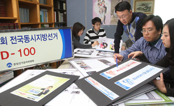 “받으면 과태료, 신고하면 포상금”
지방선거 D-100일을 하루 앞둔 21일 중앙선거관리위원회 직원들이 정부과천청사에서 유권자의 투표 참여를 독려하는 포스터 시안을 검토하고 있다. 과천=변영욱 기자