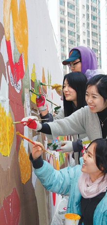21일 서울 마포구 신공덕동에 들어설 ‘마포 푸드마켓’에 벽화를 그리기 위해 자원봉사를 나온 대학생들이 벽에 알록달록한 그림을 그리며 환하게 웃고 있다. 사진 제공 마포구