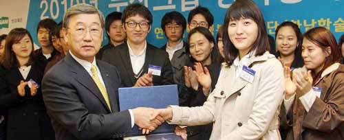 박용현 이사장(앞줄 왼쪽)이 한 학생에게 장학금을 전달하고 있다. 사진 제공 두산그룹