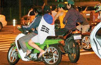 1990년대 후반 이후 국경일만 되면 오토바이를 탄 10대들의 ‘폭주’가 계속되고 있다. 경찰은 올해 폭주족이 모는 오토바이 뒷좌석에 탄 ‘여학생’ 해산에 단속 초점을 맞췄다. 지난해 8월 15일 폭주족이 서울 시내를 달리고 있는 모습. 왼쪽 오토바이 뒷좌석에 태극기를 두른 여학생이 타고 있다. 동아일보 자료 사진