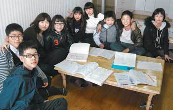 충북 청원군 강외면 만수초등학교의 오지윤(왼쪽에서 세 번째) 정지숙 교사(왼쪽에서 여섯 번째)가 자신들이 살고 있는 70㎡짜리 임대아파트에 마련한 ‘실력쑥쑥 공부방’에서 학생들과 어울려 공부하고 있다. 사진 제공 만수초등학교