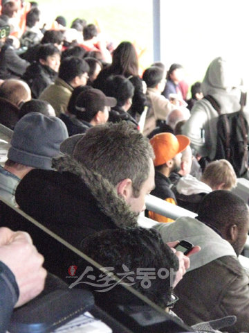 외국인이 한국-코트디부아르전의 출전선수명단을 확인하며 무언인가를 적고 있다.