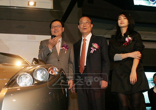 정만원 SK텔레콤 대표이사, 최시중 방송통신위원장, 광고모델 신민아(왼쪽부터)가 ‘모바일 인 비클(Mobile in Vehicle)’이 장착된 스포츠카 앞에서 포즈를 취하고 있다. ‘모바일 인 비클’은 스마트폰을 이용해 자동차를 원격제어하는 SK텔레콤의 미래기술이다. [사진제공=SK텔레콤]