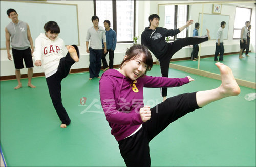 액션스쿨을 찾은 이정연(왼쪽 두 번째), 김민정(가운데) 기자가 발차기를 하며 힘겨워 하고 있다. 훈련생들은 맞고 때리는 ‘합’을 위해 수 개월 간 발차기와 구르기, 낙법 등만 수련하는 고된 과정을 거쳐야 한다.