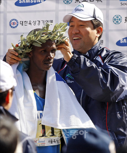 2:06:49로 국제부문 남자부 대회 신기록을 세우며 1위를 차지한 실베스터 테이멧(케냐)에게 오세훈 서울시장이 월계관을 씌워주며 축하하고 있다.