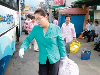 태안군의 농어촌버스 차장(안내양) 1호인 정화숙 씨가 한 노인 승객의 짐을 대신 버스에 실어주고 있다. 지명훈 기자
