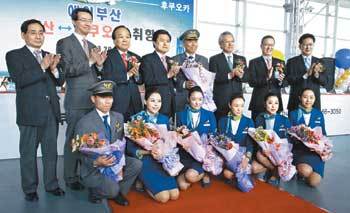 부산지역 인사 및 항공사 관계자들이 29일 부산∼일본 후쿠오카 노선에 첫 취항하는 에어부산 승무원과 함께 기념촬영을 하고 있다. 사진 제공 에어부산
