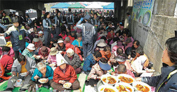 강원 원주밥상공동체가 8일 원주천 쌍다리 아래에서 마련한 ‘사랑의 점심’ 행사에서 참석자들이 식사를 하고 있다. 사진 제공 밥상공동체