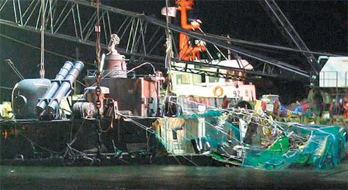 그물로 감싼 함미 절단면 14일 밤 백령도 앞바다에서 대형 크레인선이 불을 밝힌 채 천안함 함미에 마지막 3번째 쇠줄을 연결하는 작업을 하고 있다. 함미 절단면은 13일 일부 방송에서 공개됐을 때보다 더 촘촘한 녹색그물로 싸여 있는 것이 보인다. 해군은 15일 오전 9시 인양을 시작해 이날 저녁까지 마칠 예정이다. 백령도=홍진환 기자